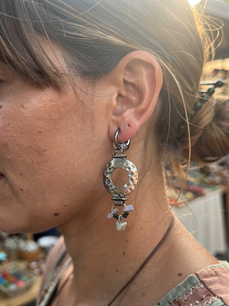 Close-up of a person wearing a silver earring with a blurred background