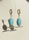 Turquoise beaded earrings with gold accents on a white background