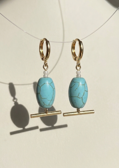 Turquoise beaded earrings with gold accents on a white background
