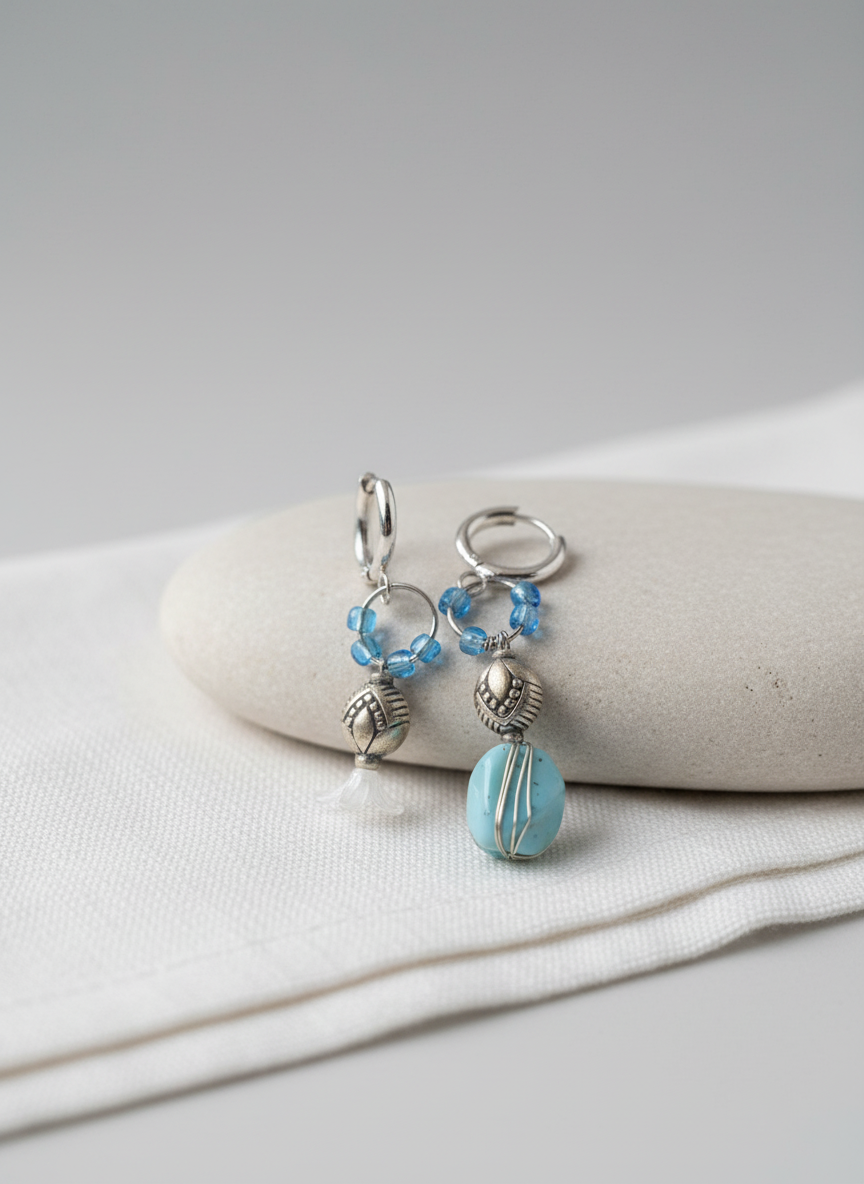 Pair of earrings with blue beads on a white surface